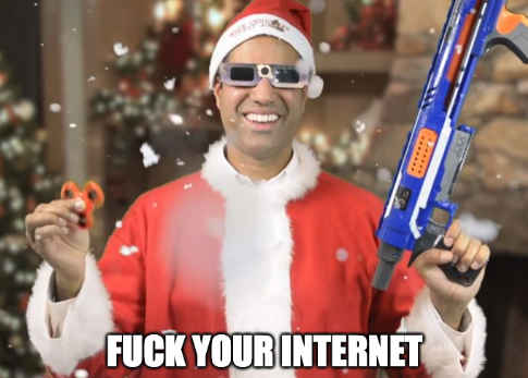 A man in a santa suit with a nerf gun and sunglasses